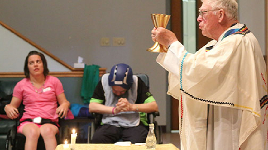 Father Blaney consecrates wine during a 2017 Mass