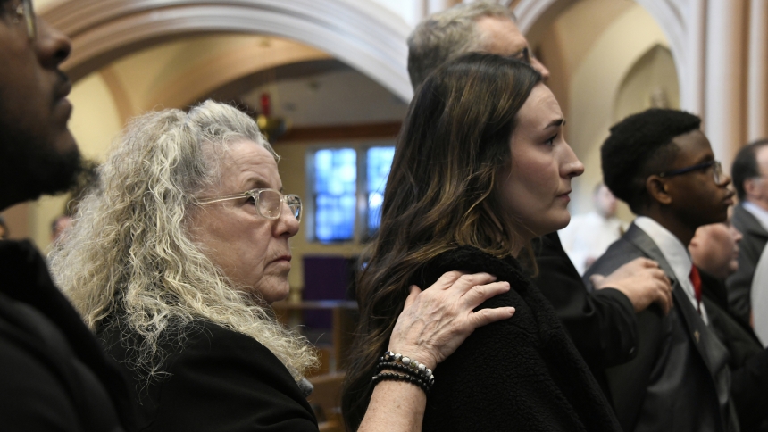 Godparent Karen Kirk of Nativity of Our Savior in Portage places her hand on the shoulder of catechumen Skylar McElheny during the Rite of Election service at the Cathedral of the Holy Angels in Gary on Feb. 18. "They really make me feel like I belong in the Catholic Church," McElheny said of Kirk and other members of the Rite of Christian Initiation for Adults (RCIA) team she studied with in preparation for her baptism at the Easter Vigil on March 30. (Anthony D. Alonzo photo)