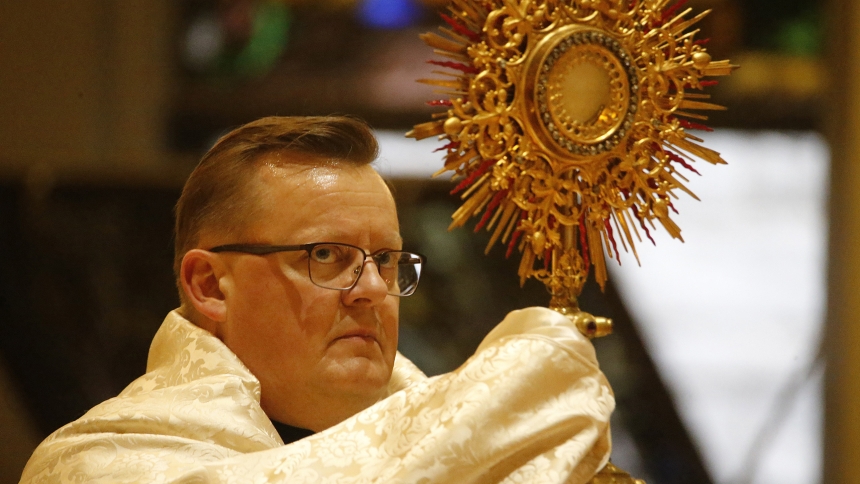 Father Dave Kime, pastor at Queen of All Saints in Michigan City, carries the monstrance in a Eucharistic procession on Corpus Christi Sunday in 2023, one of a number of processions hosted in the Diocese of Gary as the second year of a National Eucharistic Revival continued. This summer, the celebration will climax with a National Eucharistic Congress in Indianapolis, where a Diocesan Day is planned by the Gary diocese for Saturday, July 20. (Bob Wellinski/file photo)
