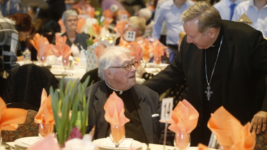 Bishop Robert J. McClory visits with Father Dennis Blaney during the Share Foundation’s 33rd annual spring luncheon at Halls of St. George, Schererville IN. (Bob Wellinski photo) 