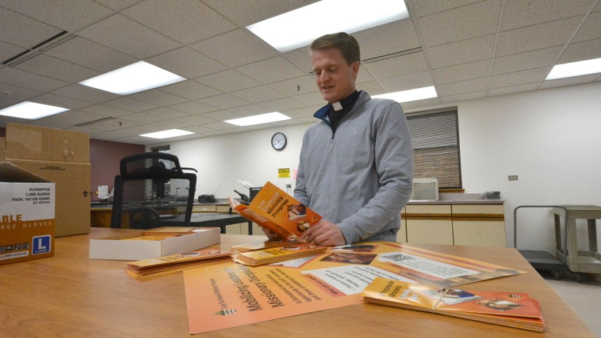 Father Declan McNicholas, director of missionary discipleship and evangelization and director of the lay ecclesial ministry, reviews newly printed literature designed to promote the LEM program, at the Pastoral Center in Merrillville on March 26. The diocesan program is a multi-year educational initiative offered to develop deeper knowledge and inspire those involved with or pursuing various ministries in the local Church. (Anthony D. Alonzo photo)