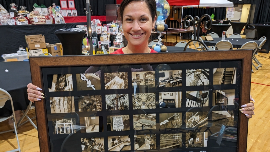 Renee Scearce displays framed photographs taken by eighth graders entitled, "St. Michael Through Our Eyes." This item was one of dozens auctioned April 13 during the St. Michael the Archangel School fundraiser, Passport to Our Heritage." (Lynda J. Hemmerling photo)