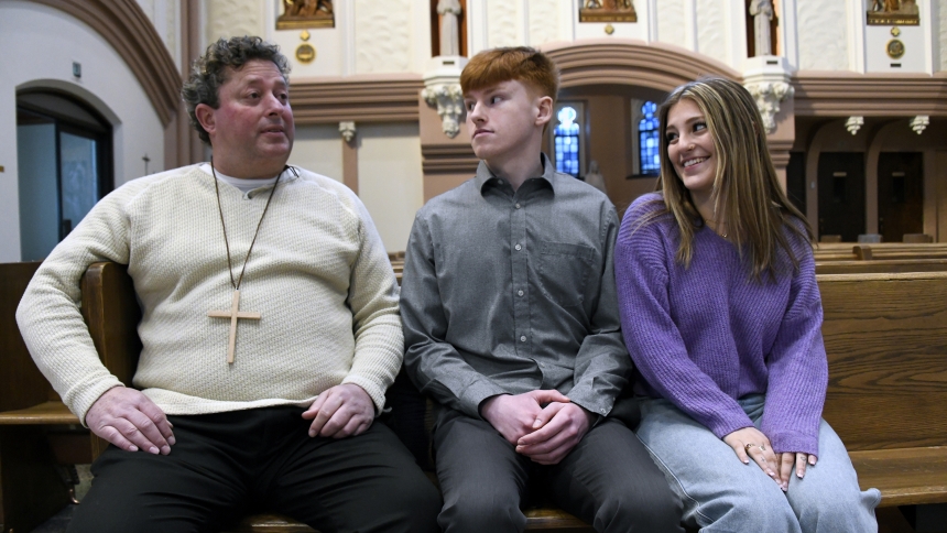George Veenstra Jr. sits with his children George Veenstra III, 19, and Gianna Veenstra, 17, in the Cathedral of the Holy Angels, awaiting the Rite of Election on Feb. 18 in Gary. Veenstra, Jr., who entered the Catholic Church at the Easter Vigil at St. Patrick church in Chesterton, endured with his family the loss of his wife and his children's mother, June Veenstra, who passed away in 2022 after a battle with cancer. He hopes to lead his children deeper into the faith and find peace in life. (Anthony D. A
